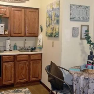 A cozy kitchen and dining area with wooden cabinets and a small table.
