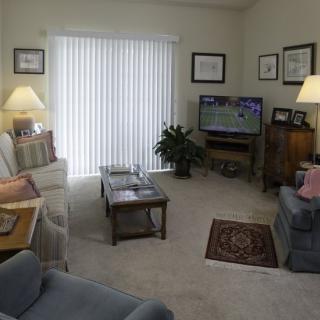 A cozy living room with comfortable seating, a TV, and soft lighting.