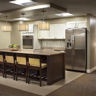 A modern kitchen featuring a large island with bar stools and stainless steel appliances.