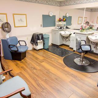 An interior view of an empty hair salon with chairs and mirrors.