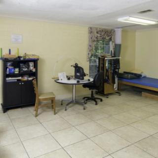 A small office space featuring a desk with a computer, a chair, and shelves.
