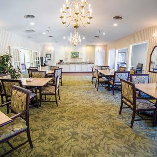 A spacious dining room with multiple tables and a chandelier.