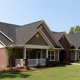 A suburban house with a neatly maintained lawn and a cozy front porch.