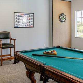 A game room featuring a pool table and a dartboard.