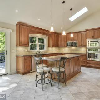 Spacious kitchen with wood cabinets, a central island, and skylight.