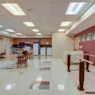 A spacious physical rehabilitation room equipped with exercise tools and therapy bars.