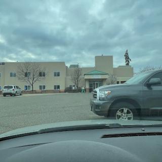 A view of a building from a parked car on a cloudy day.