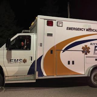 An emergency medical services ambulance parked at night.