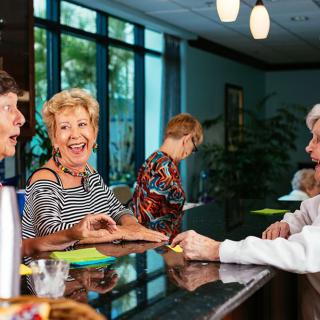 A lively conversation takes place between people at a reception desk.