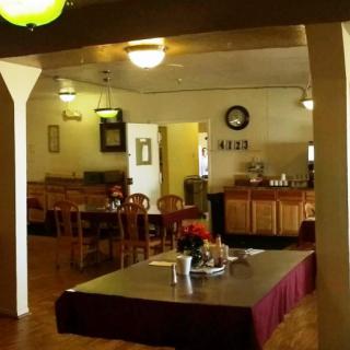 A cozy restaurant interior featuring a dining area with tables and chairs.