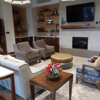 A cozy living room with modern furniture, a fireplace, and a large television.