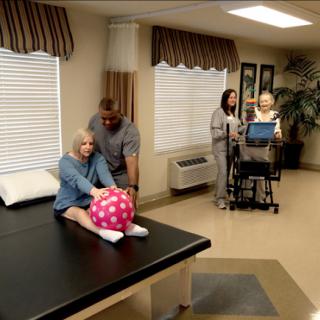 A physical therapy session in a healthcare facility, focusing on patient rehabilitation using a therapy ball.