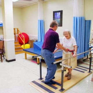 A physical therapist assists an elderly woman during a rehabilitation session.