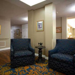 A cozy lobby seating area with two patterned chairs and a small table.