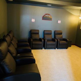 A cozy home theater room with comfortable recliner seating.