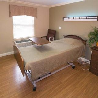 A hospital room featuring a single bed with medical equipment and furnishings.