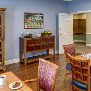 A cozy dining area with wooden furniture and a sideboard against a blue wall.