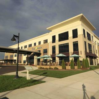 A modern restaurant with outdoor seating under a cloudy sky.