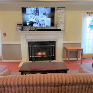 A cozy living room with a fireplace and television, complemented by a comfortable sofa and coffee table.