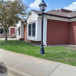 A well-maintained residential building with a streetlamp and green lawn.