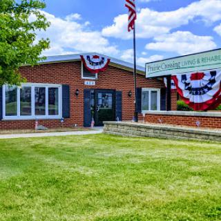 A charming brick building adorned with patriotic decorations and an American flag, set against a clear blue sky.