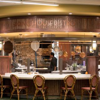 A cozy restaurant kitchen with a welcoming dining counter and staff preparing meals.