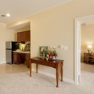A cozy living space featuring a small kitchen area, decorated table, and an open doorway leading to another room.