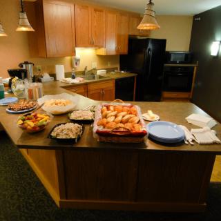 A kitchen counter set up with a variety of snacks and dishes, ready for a party or gathering.