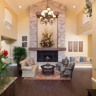 A luxurious living room featuring a grand stone fireplace, comfortable seating, and elegant decor.