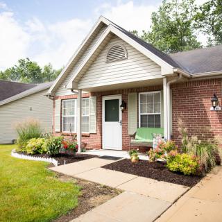 A charming brick house with a well-maintained front yard and garden.