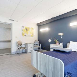 A modern hospital room with a patient bed and contemporary furnishings.