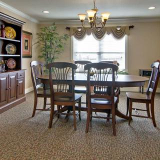 A dining room with a wooden table and chairs, a chandelier, and decorative elements.