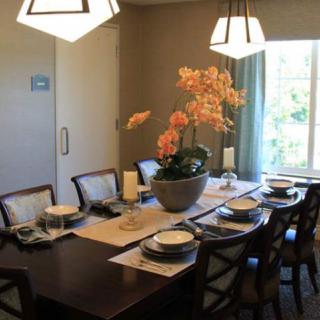 A well-set dining room table with elegant decor and a central orchid arrangement.