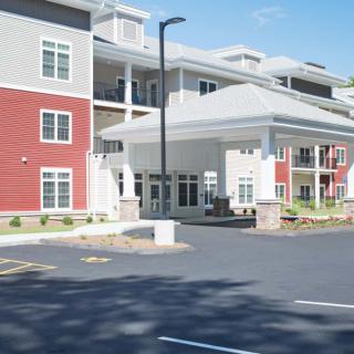 Modern residential apartment building with red and white facade.