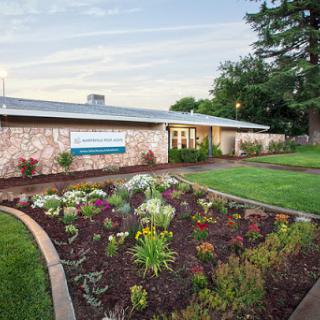A well-maintained building with a vibrant garden in the foreground.