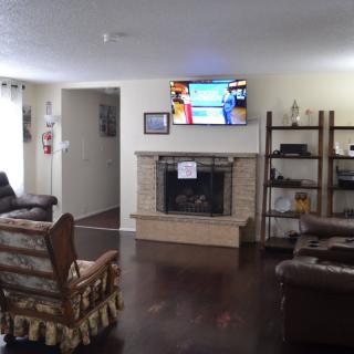 A cozy living room featuring a fireplace, comfortable seating, and a television.