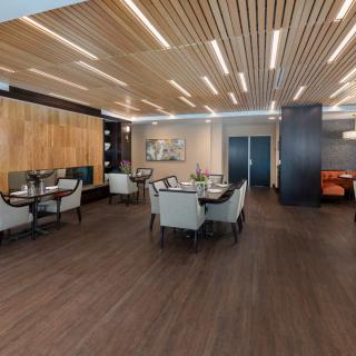 A modern dining area with wooden ceiling and elegant indoor seating arrangement.