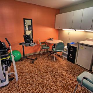A rehabilitation room equipped with various medical and exercise equipment.