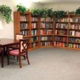 A cozy library corner with bookshelves, a table, and chairs.