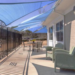 A sunny patio with comfortable seating and a protective canopy.
