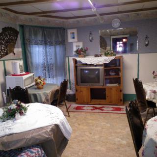 A vintage-style living room with retro decor and an old television, featuring cozy table settings.