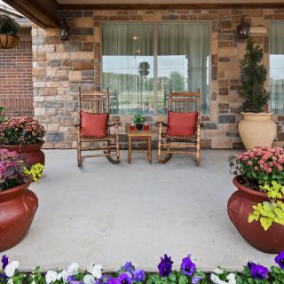 A cozy porch with rocking chairs and colorful flower pots.