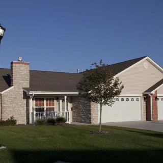 A suburban house with a garage and a well-maintained lawn.