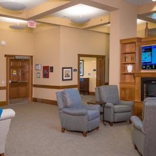A comfortable lobby area with armchairs, a television, and soft lighting.