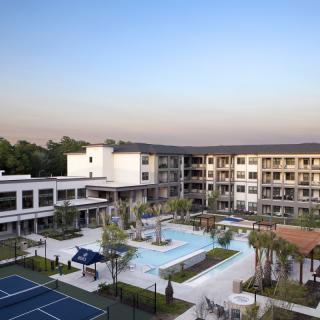 Aerial view of a resort featuring a pool and tennis courts.