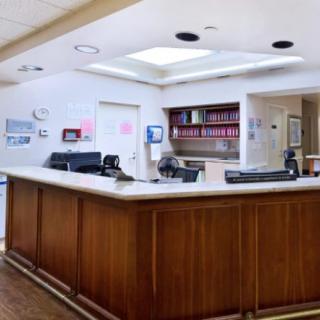 A hospital reception desk with office equipment and paperwork.