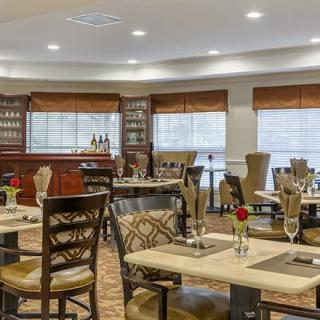 A cozy restaurant interior with neatly arranged tables and a bar in the background.