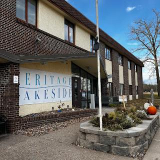 A view of a brick building featuring signage and landscaped surroundings.