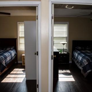 Two adjacent bedrooms with identical layouts and furniture, separated by a central wall.