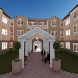 A beautifully designed residential building with a welcoming courtyard, illuminated in the evening light.